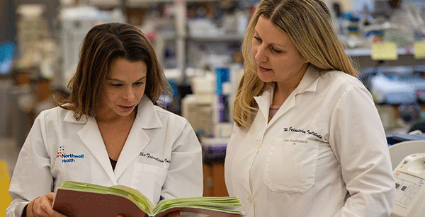 Female researchers reading a book in the lab