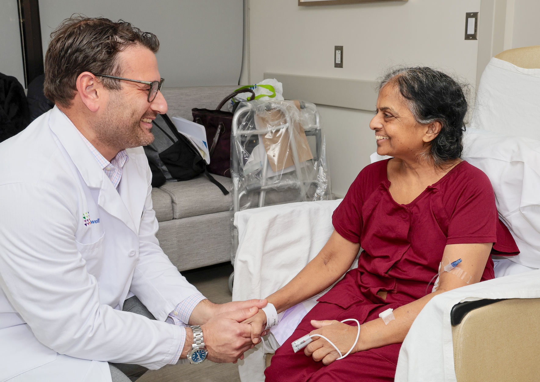Physician holds patients hand during conversation